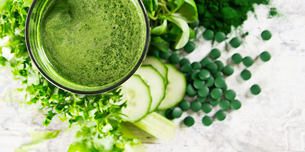 Boisson de chlorella en verre et comprimés avec des tranches de concombre