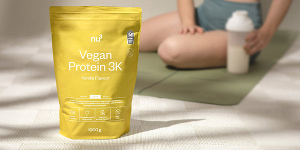Vegan Protein 3K Vanille devant une sportive sur un tapis de fitness